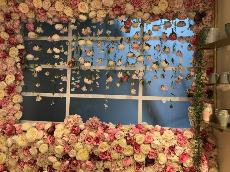 A photo of a window surrounded by a wall of roses at Élan Café in London, England.