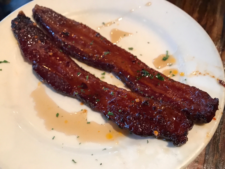 A photo of two juicy pieces of Millionaire's Bacon at Kitchen Story in San Francisco, California.